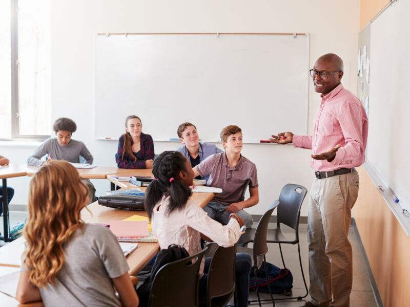 An educator is teaching self-control strategies to the class. Helping students improve their self-regulation.